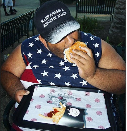 obese man eating Dandy Diner burger with Make America Healthy Again cap